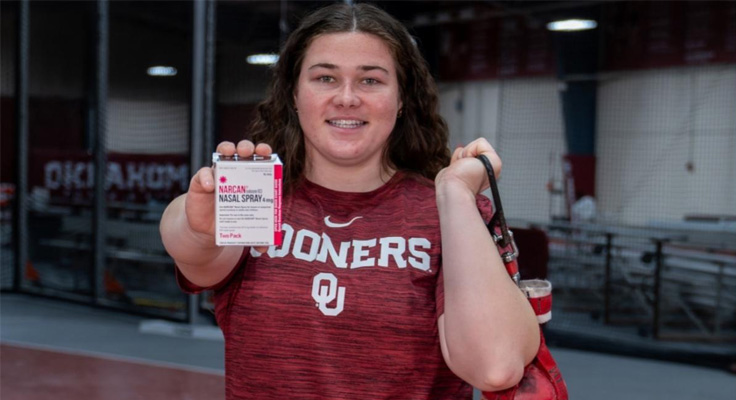 Female athlete holding a box of naloxone from an ODRescue Kit